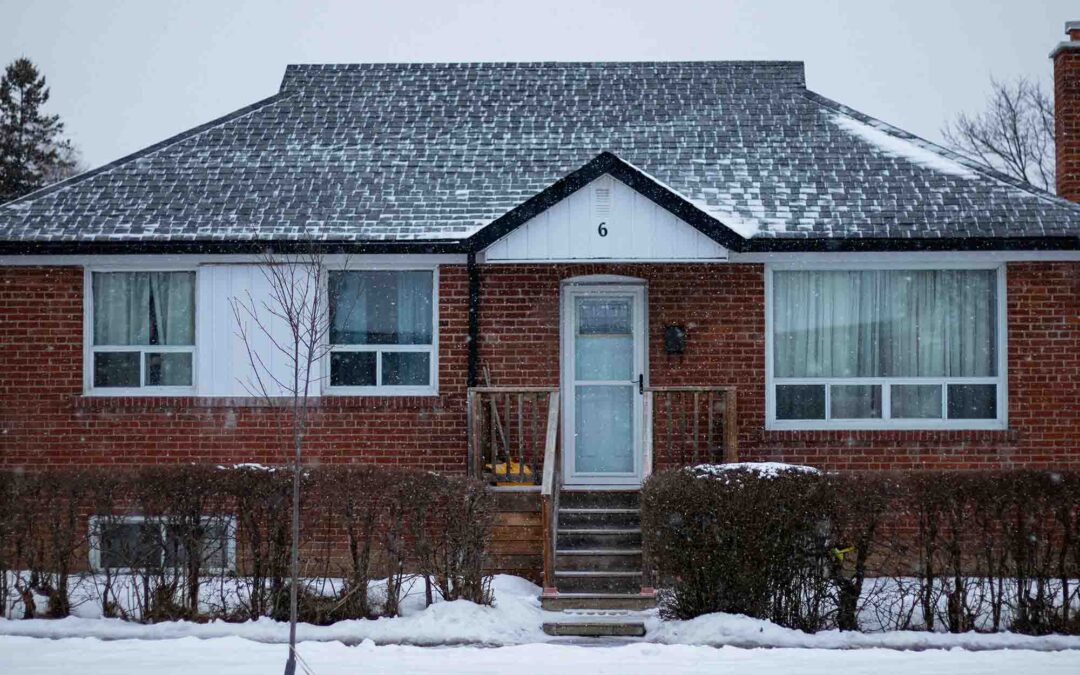 Snow-covered suburban brick house